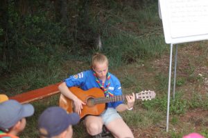 clara en solo à la guitare qui embrasse la messe