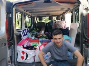 Flavien prenant la pose devant un Bébert chargé de dons pour le centre.